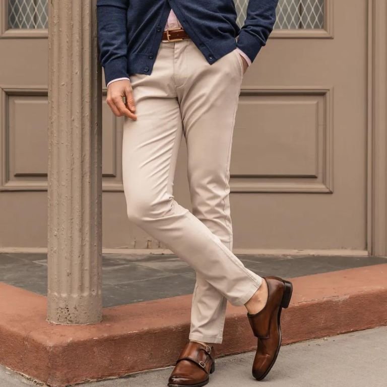 Old Money Aesthetic Men's outfit with beige chinos matched with brown leather belt and navy cardigan